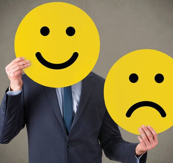 Afbeelding van een lachende emoji ter hoogte van het gezicht van een man